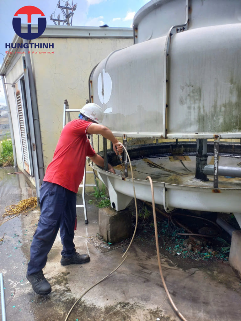 kỹ thuật của Hưng Thịnh đang vệ sinh rong rêu, cặn bẩn cho tháp giải nhiệt
